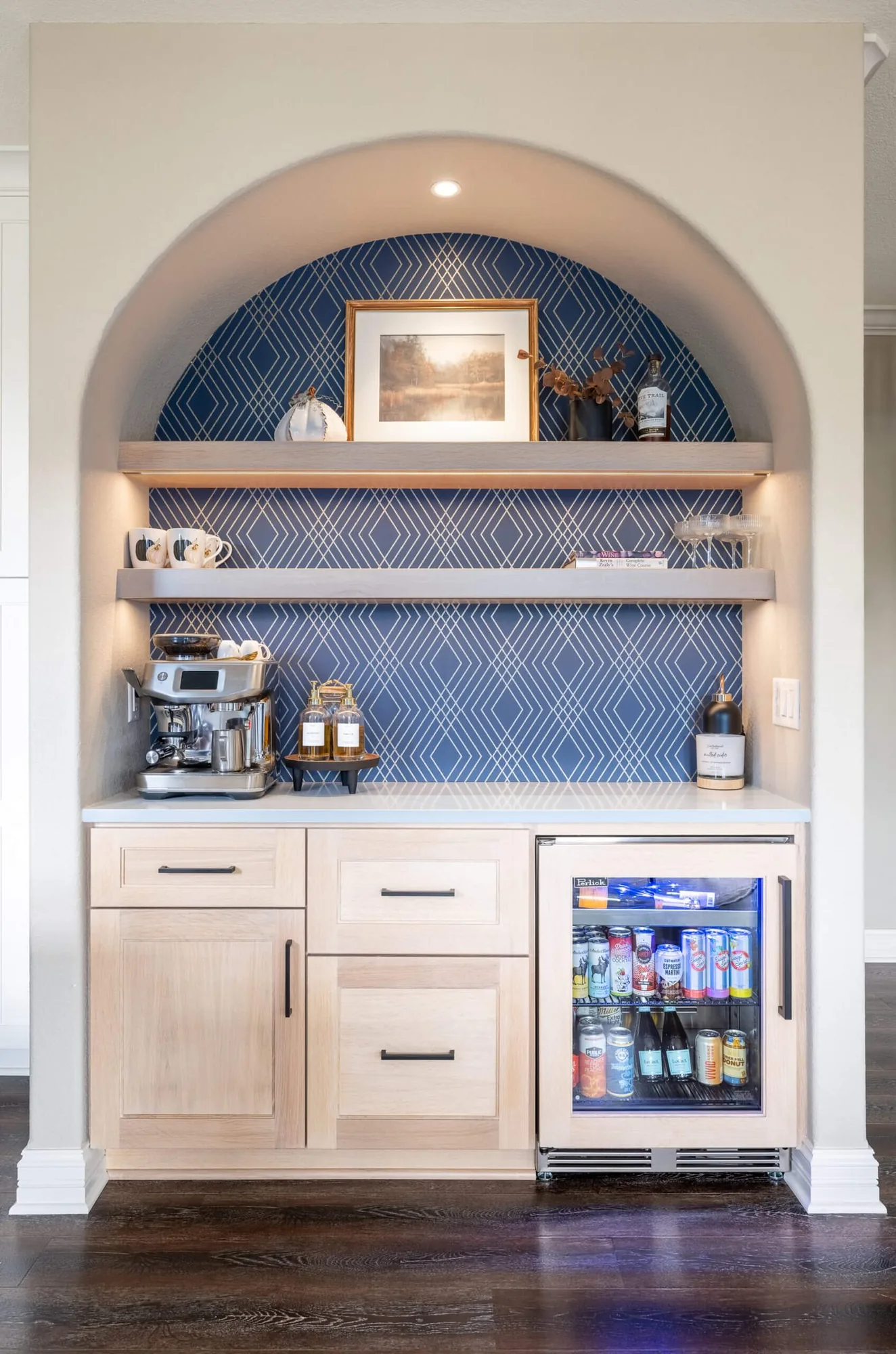 Arched niche with a coffee station, open shelving, and blue patterned tile