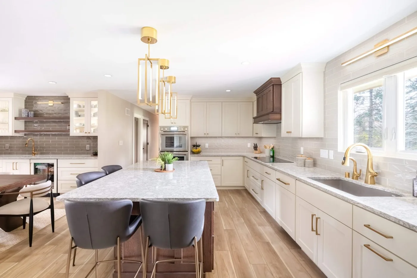 Open kitchen and dining room with a long island, pendant lighting, and pale cabinetry